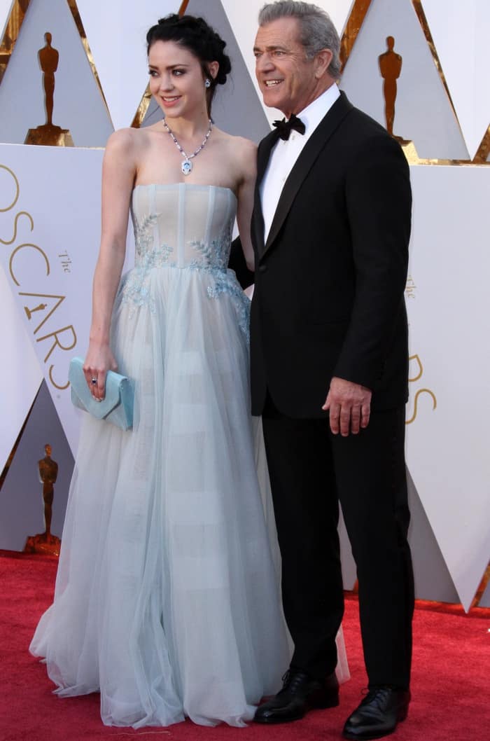 Rosalind Ross dazzles in a powder blue strapless gown alongside Mel Gibson in a classic Giorgio Armani tuxedo at the 89th Academy Awards red carpet