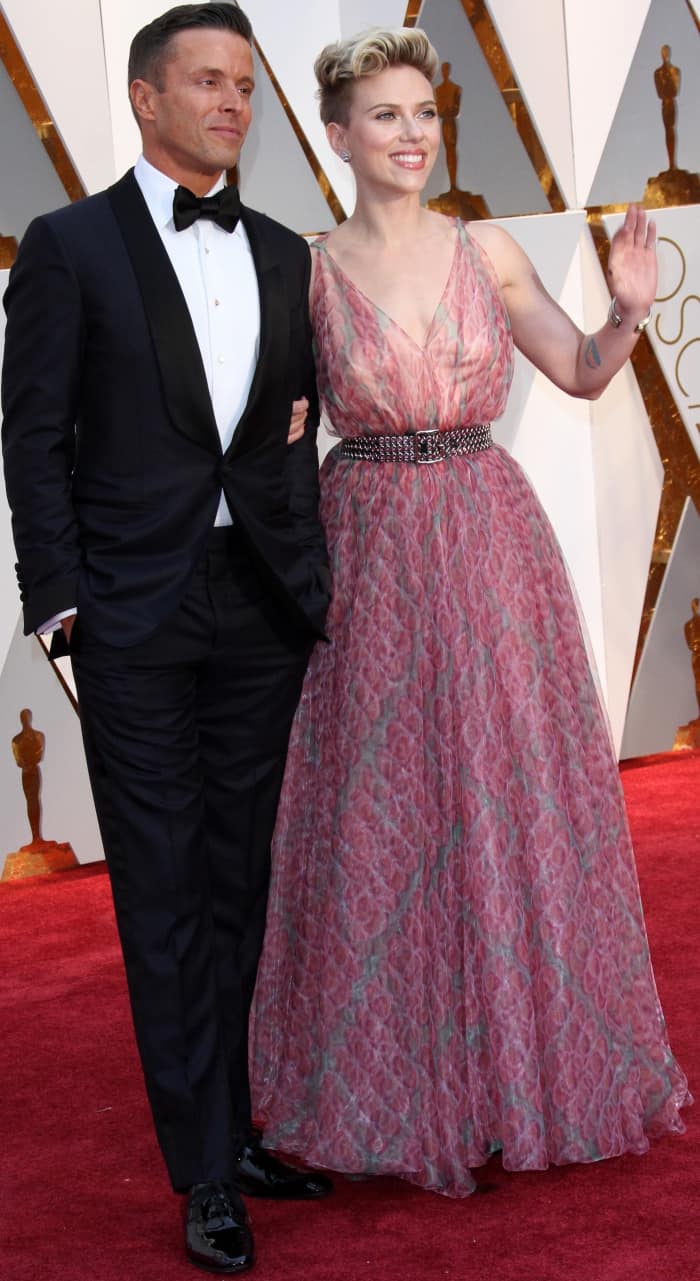 Scarlett Johansson dazzled in a flowing pink Azzedine Alaïa gown with a studded belt, while her date complemented her elegance in a classic black tuxedo