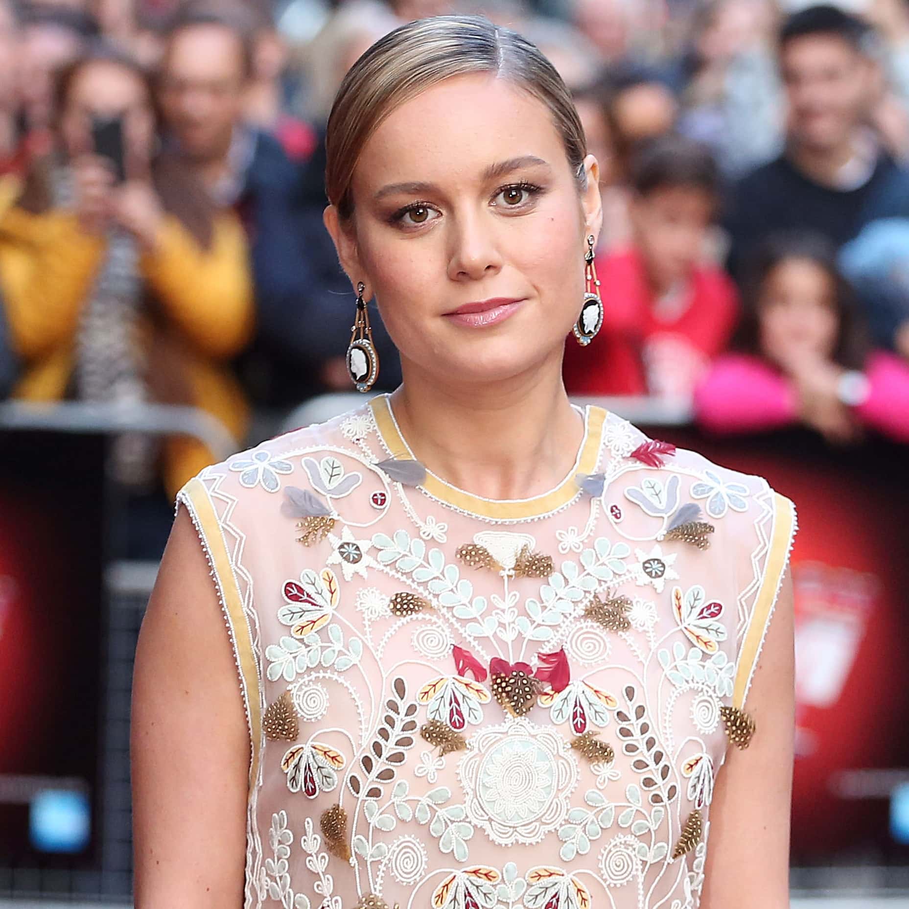 Brie Larson stuns in a delicate floral-embroidered sheer dress complemented by statement earrings