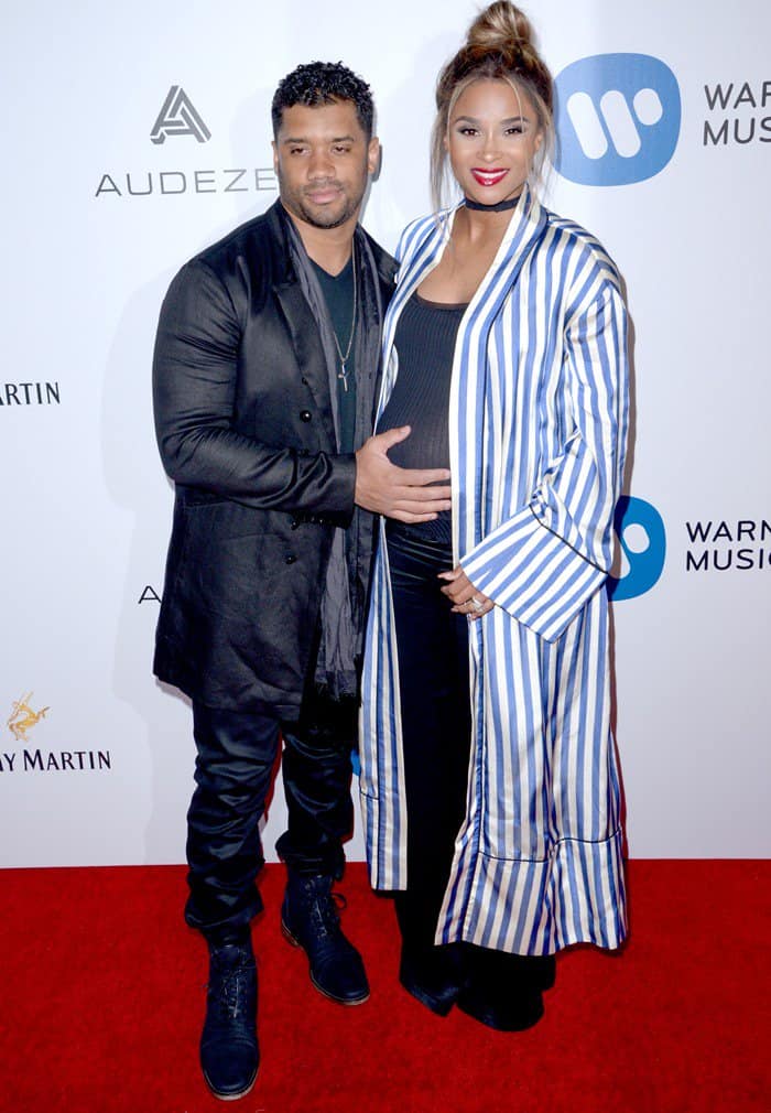 Ciara stuns in a striped duster and chic maternity wear, while Russell keeps it sleek in all-black for a coordinated red carpet look