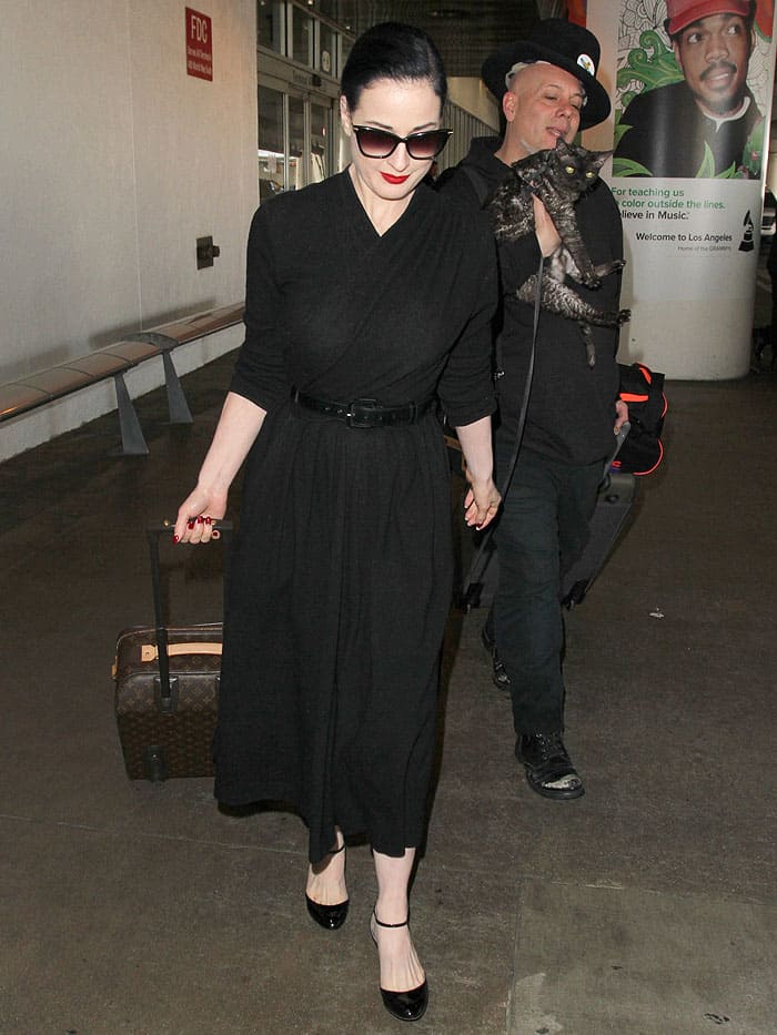 Dita Von Teese, her cat, Aleister, and a male companion making their way through LAX