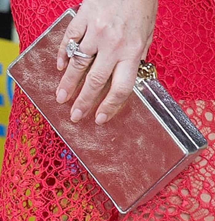 Elizabeth contrasts her red dress with a silver clutch