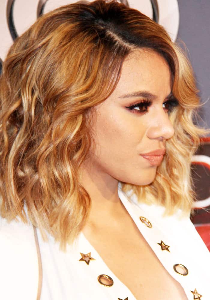 Dinah Jane stuns with voluminous honey-blonde waves and a star-embellished white blazer, exuding effortless glamour with a bold yet sophisticated red carpet look