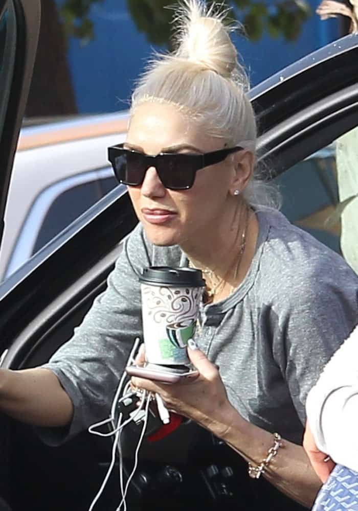 Gwen Stefani wears sunglasses and a three-quarter sleeved gray top