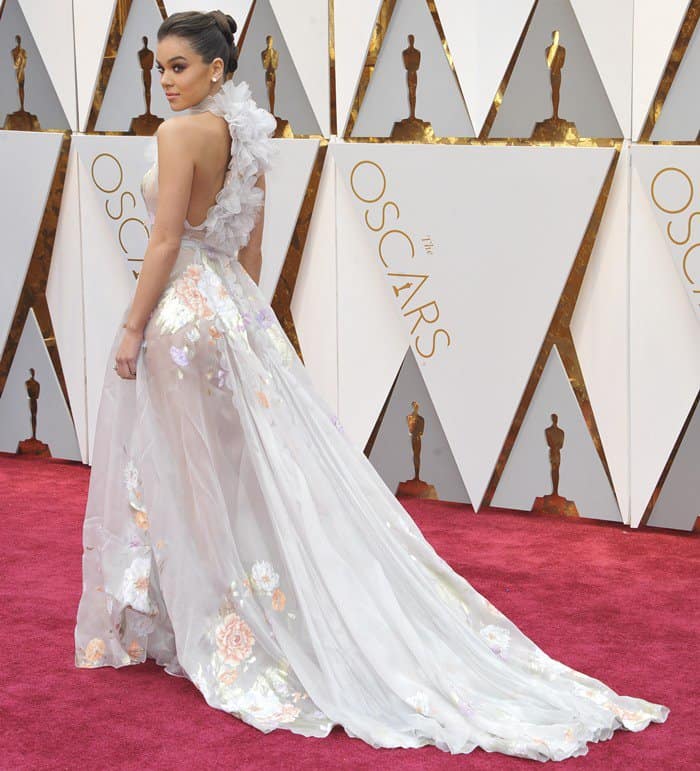 Hailee Steinfeld radiates elegance in a sheer Ralph & Russo gown with cascading floral details and a dramatic train at the 2017 Oscars