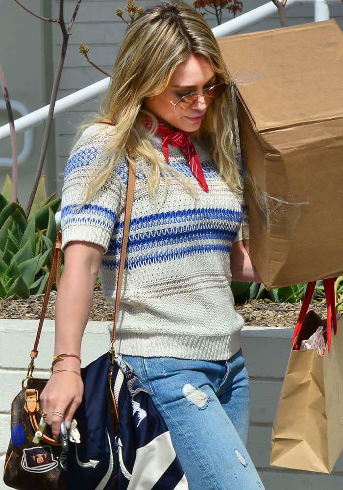 Hilary Duff shows off her strength by carrying her mystery box with one hand