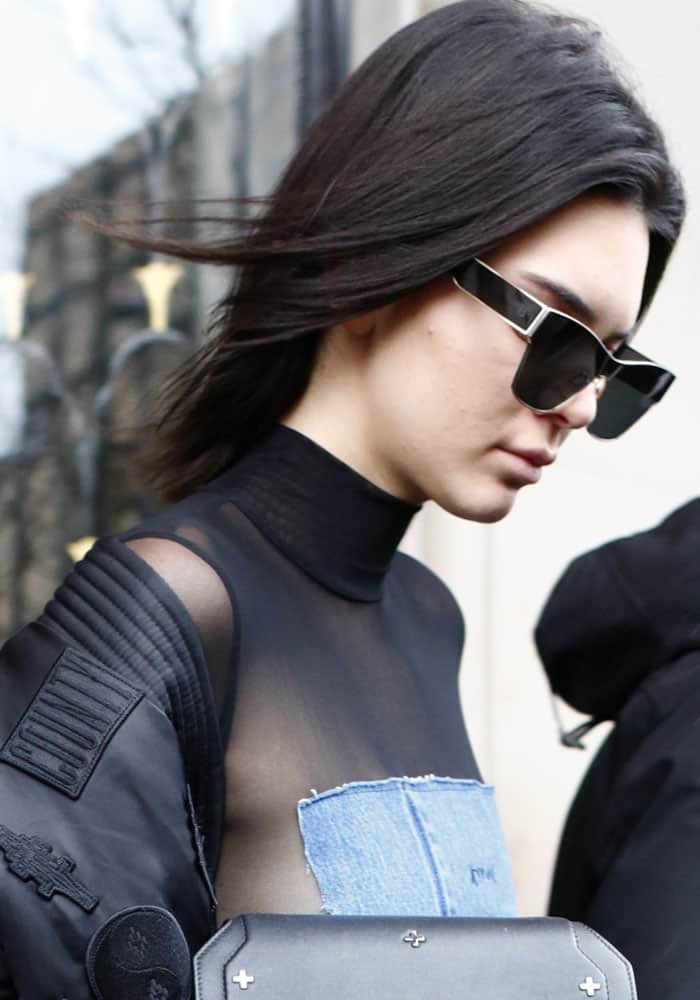 Kendall Jenner keeps it sleek with straight, windswept hair and bold geometric sunglasses during her Paris outing