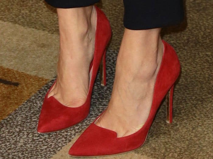 Red suede pointy-toe pumps with vamp notches on Lauren Cohan