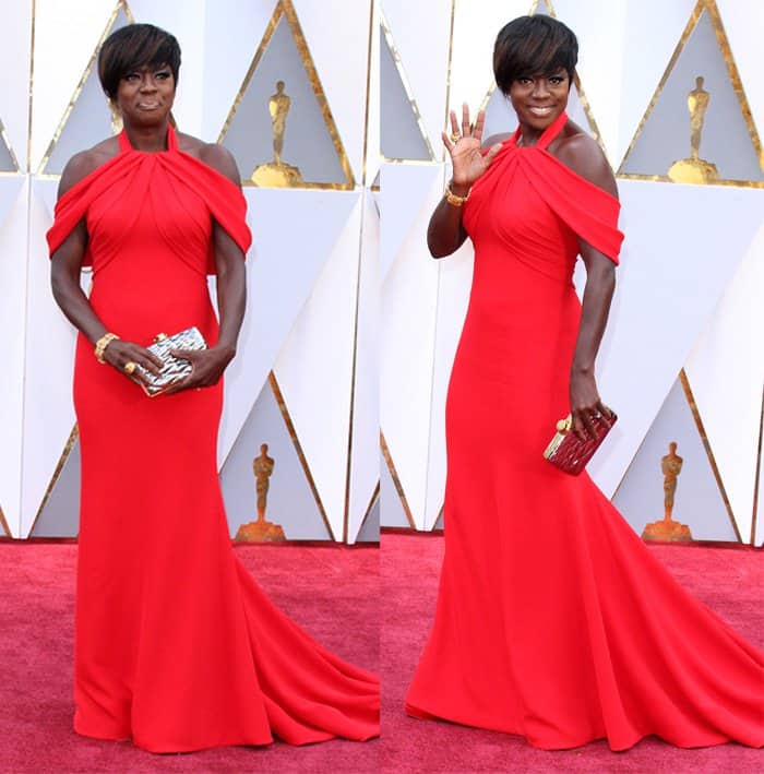 Viola Davis radiates confidence and elegance in a striking red Armani gown featuring an off-the-shoulder design and a flowing train that commands attention on the red carpet
