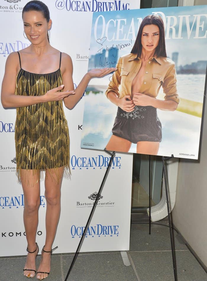 Adriana Lima wearing a black and gold cocktail dress from Misha Collection and black and gold leather sandals from Giuseppe Zanotti