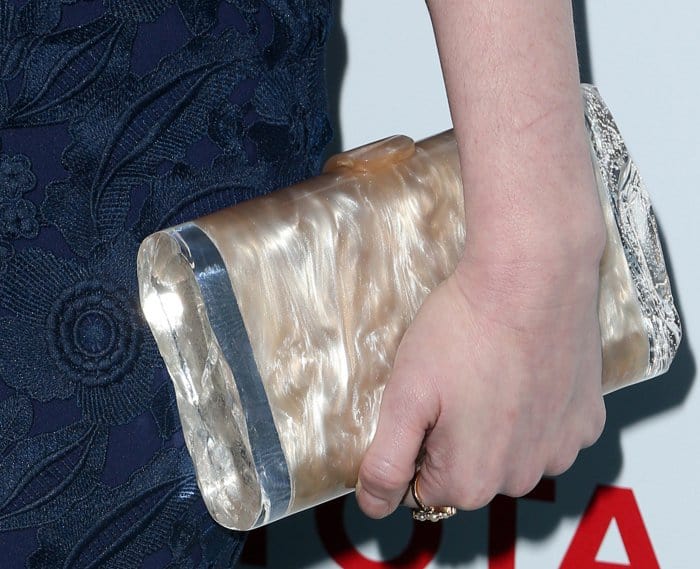 Christina Hendricks complemented her navy lace gown with a stunning Edie Parker marble clutch featuring a pearlescent finish and metallic accents