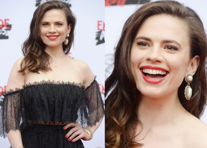 Hayley Atwell radiated glamour with voluminous side-swept waves, bold red lips, and statement pearl drop earrings that added a touch of vintage elegance to her gothic-chic ensemble