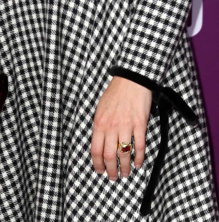 Sarah Paulson adds a regal touch with a statement ruby ring, perfectly complementing her neatly manicured nails and the vintage-inspired velvet-trimmed gingham dress