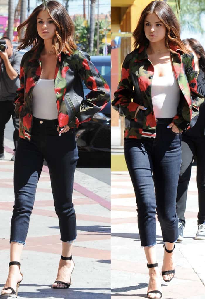 Selena Gomez wearing a Coach varsity jacket, Isabel Marant Etoile tank top, J Brand jeans, and Gianvito Rossi "Portofino" sandals while out and about in Los Angeles