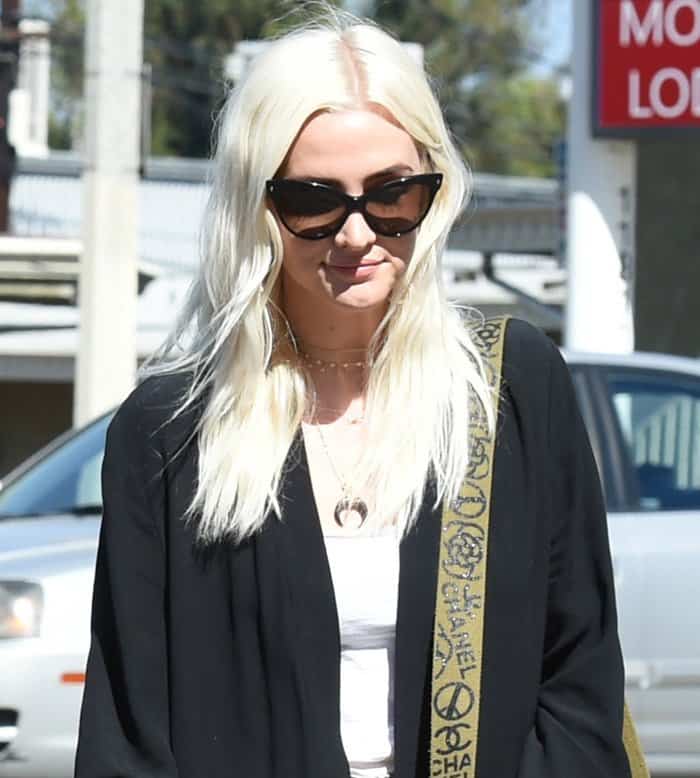 Ashlee Simpson kept it effortlessly cool with tousled platinum blonde waves, chic cat-eye sunglasses, and a relaxed black-and-white outfit accented by a statement Chanel bag strap