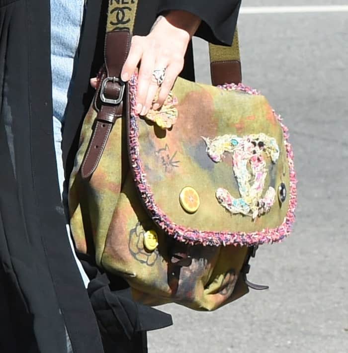 Ashlee Simpson carried a rare Chanel Graffiti Messenger Bag from the 2015 collection, featuring a distressed canvas design, colorful embroidery, playful patches, and a fringed trim for a bold, street-style edge
