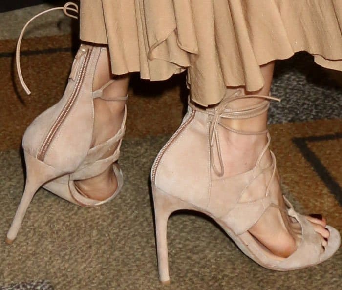 Bellamy Young wears a youthful pair of Stuart Weitzman "Legwrap" sandals in nude suede