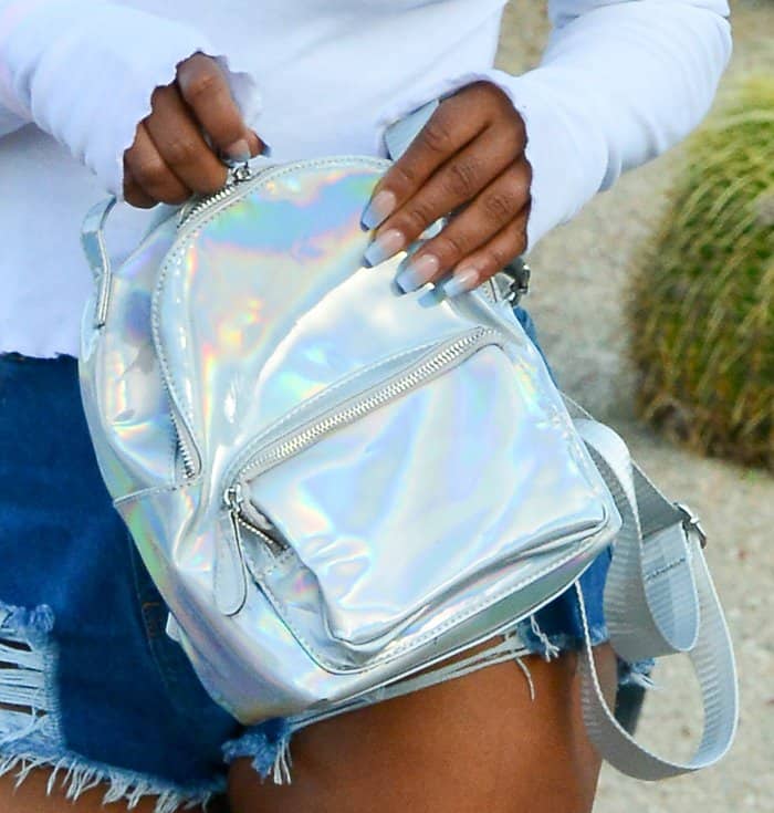 Christina Milian added a futuristic touch to her Coachella look with a compact, iridescent holographic mini backpack