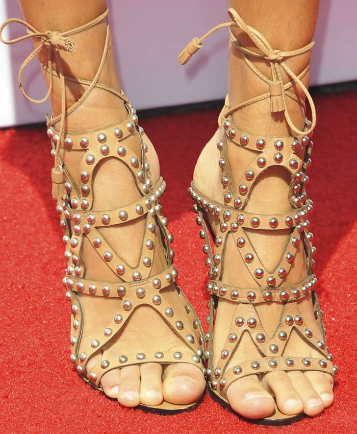 Kelly wears a studded pair of Sophia Webster "Mila" sandals in tan leather
