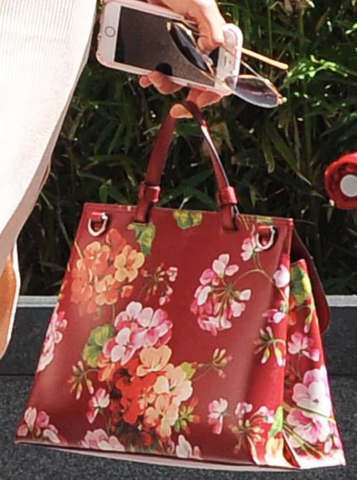 Kelly adds a pop of color to her look with a floral tote