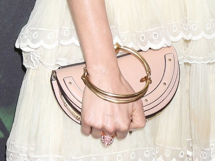 Sienna carrying a blush pink Chloé “Nile” minaudière, instantly recognizable by its signature gold-tone bracelet handle and sleek half-moon silhouette