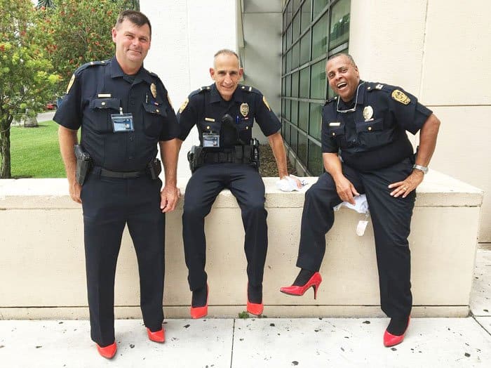Policemen from Florida Atlantic University Police Department show off their red pumps