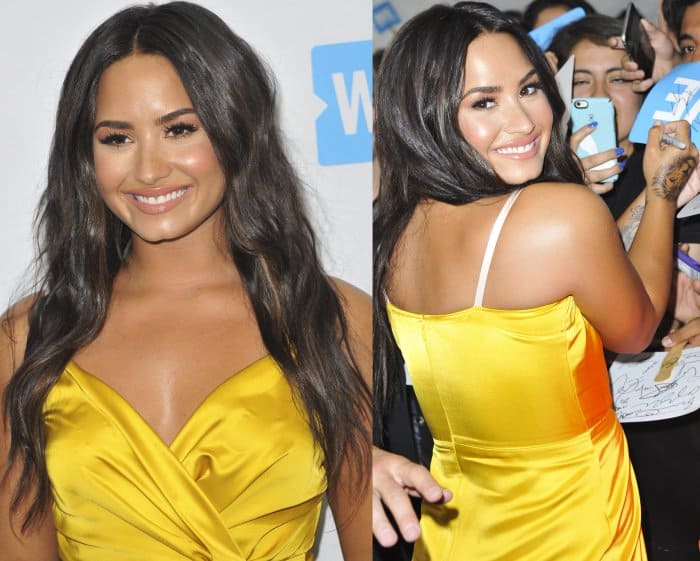 Demi Lovato dazzles at the WE Day event held at The Forum in Inglewood, California, on April 27, 2017, wearing a vibrant yellow silk dress with contrasting white straps and her signature radiant smile