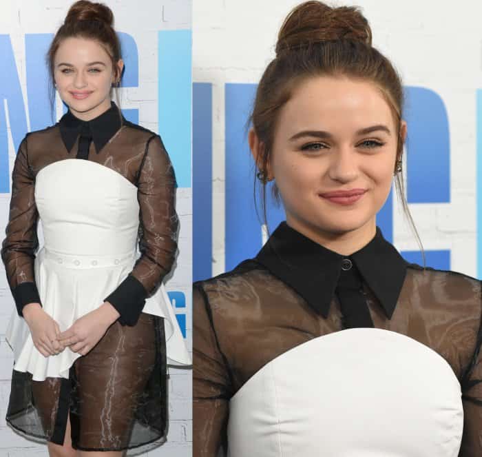 Joey King styles her hair in a chic high bun, showcasing her delicate earrings and completing her modern monochromatic look