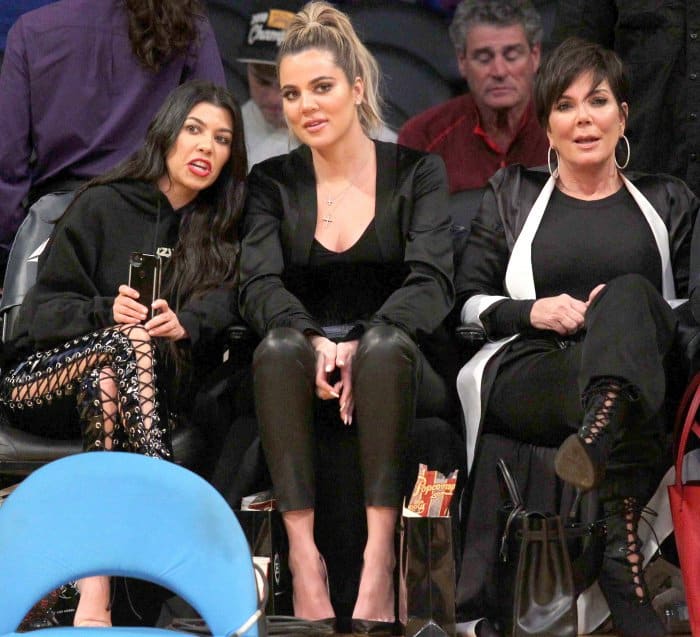 Kourtney Kardashian wearing Yeezy sandals, Khloe Kardashian wearing black pointy-toe pumps, and Kris Jenner wearing black lace-up booties at Lakers vs. Cavaliers basketball game