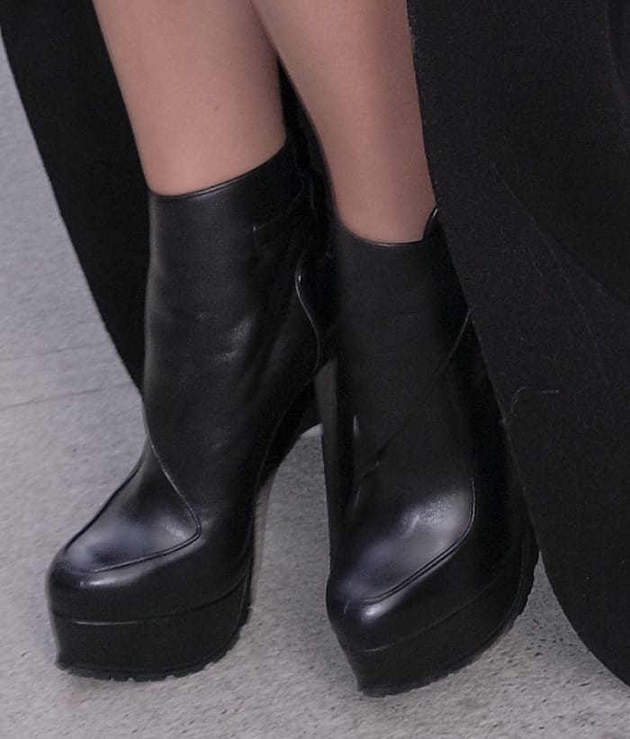 Hailee pairs her outfit with black leather platform boots also from Vera Wang