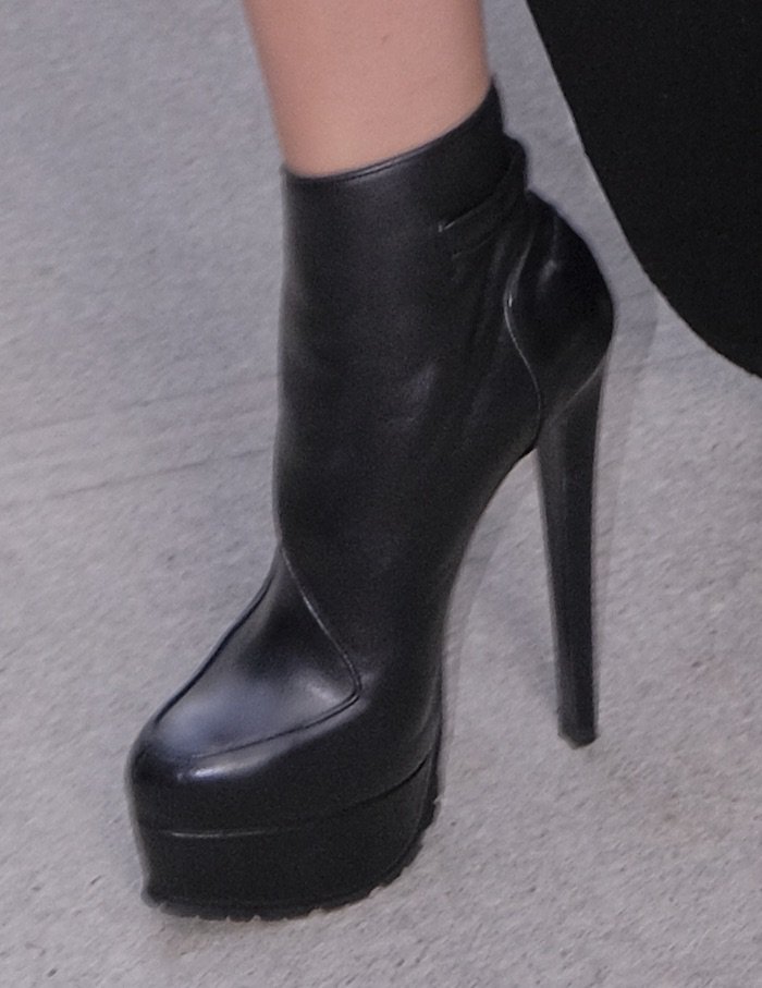 Hailee pairs her outfit with black leather platform boots also from Vera Wang