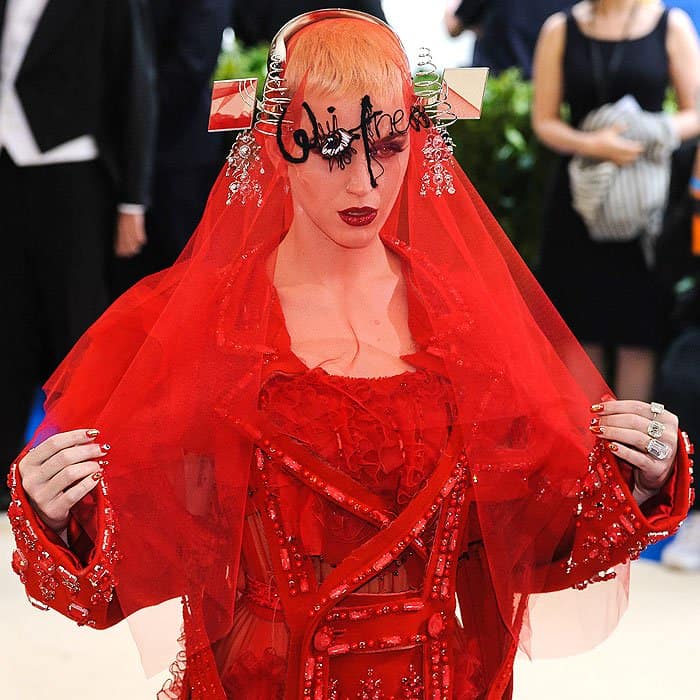 Katy Perry dazzles with a unique headpiece featuring intricate metal swirls and mirrored accents at the Met Gala 2017