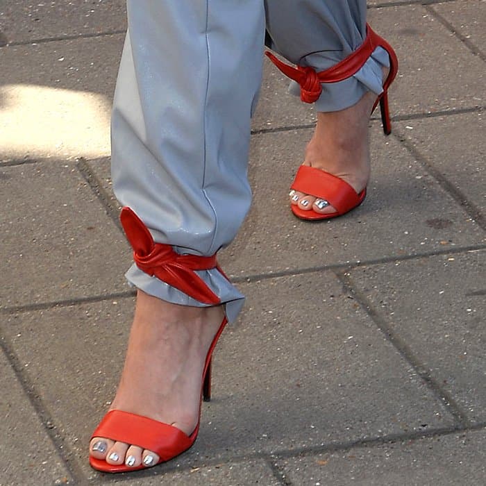 Closeups of Stella Luna red leather ankle-tie sandals on Katy Perry.