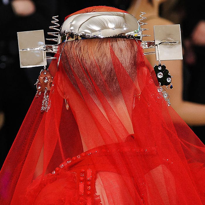 An up-close look at Katy Perry's statement headpiece adorned with swirled metal and compact mirrors, encapsulating the Met Gala's spirit of artistic and bold fashion statements