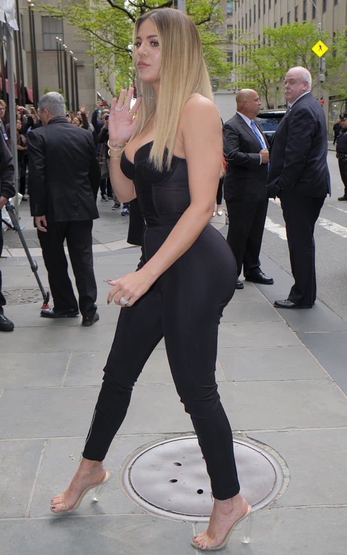Khloé Kardashian showing off her toned figure in Versace pants and a bustier top