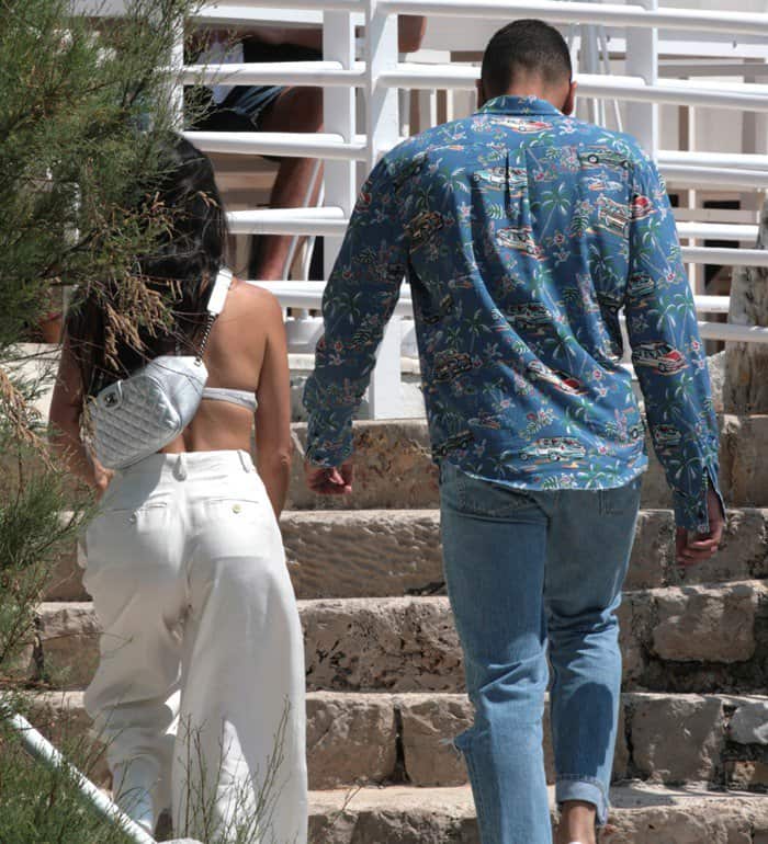 Kourtney Kardashian in a white bralette-and-pants ensemble