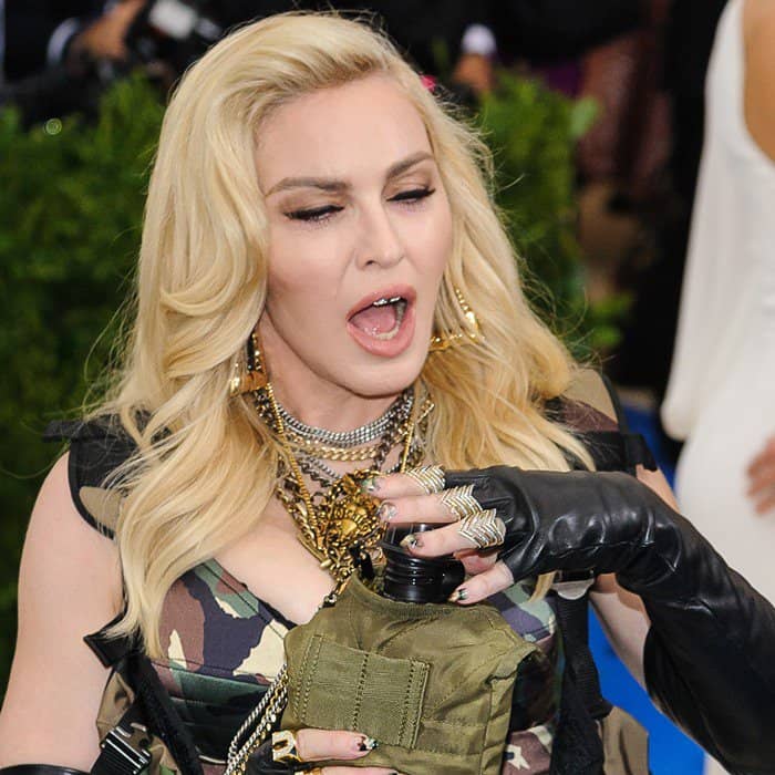 Madonna accessorized her camouflage Met Gala look with layered silver chains, gold statement necklaces, stacked rings, and edgy hoop earrings for a bold, maximalist finish