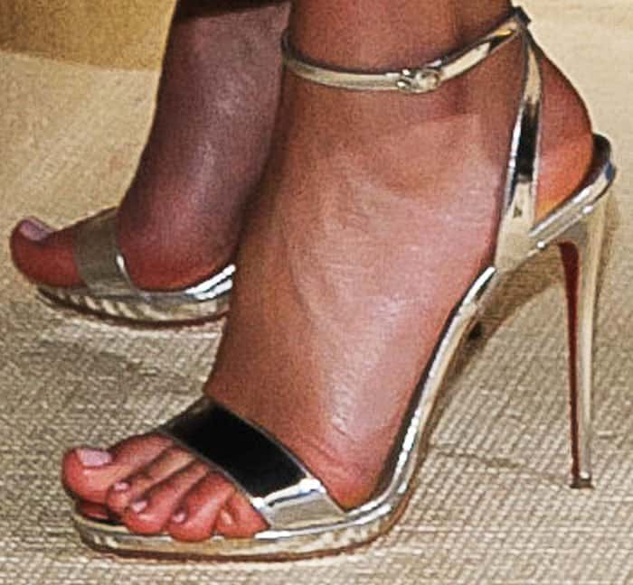 Miranda wears a pair of metallic sandals by Christian Louboutin