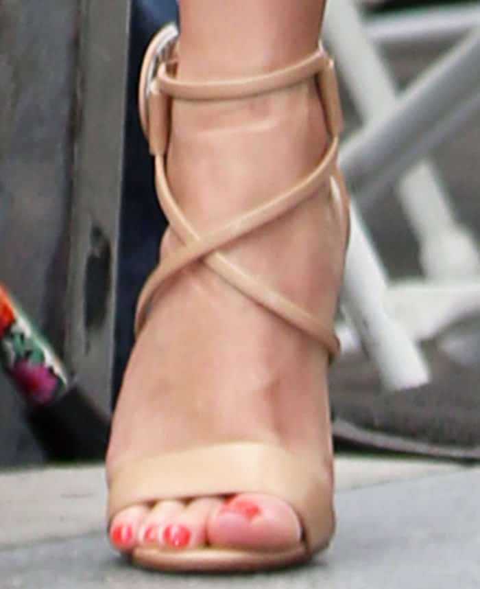 A close-up of Reese Witherspoon's nude Christian Louboutin "Choca" sandals reveals a polished coral pedicure that adds a fresh pop of color to her leg-lengthening look