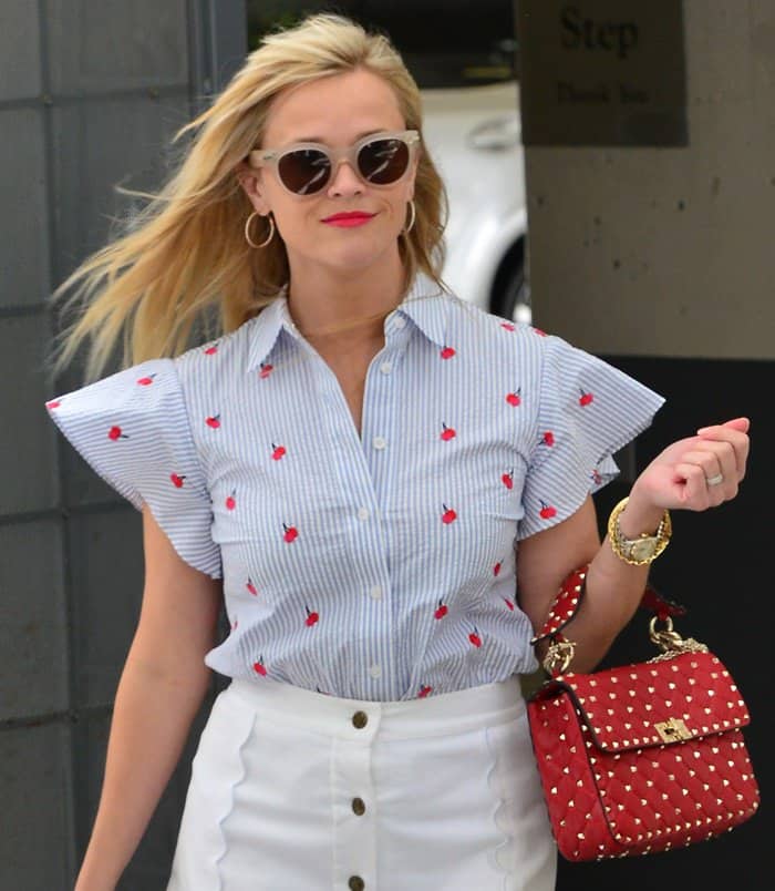 Reese was wearing pieces from her line, Draper James, and paired the outfit with a Valentino Rockstud Spike bag