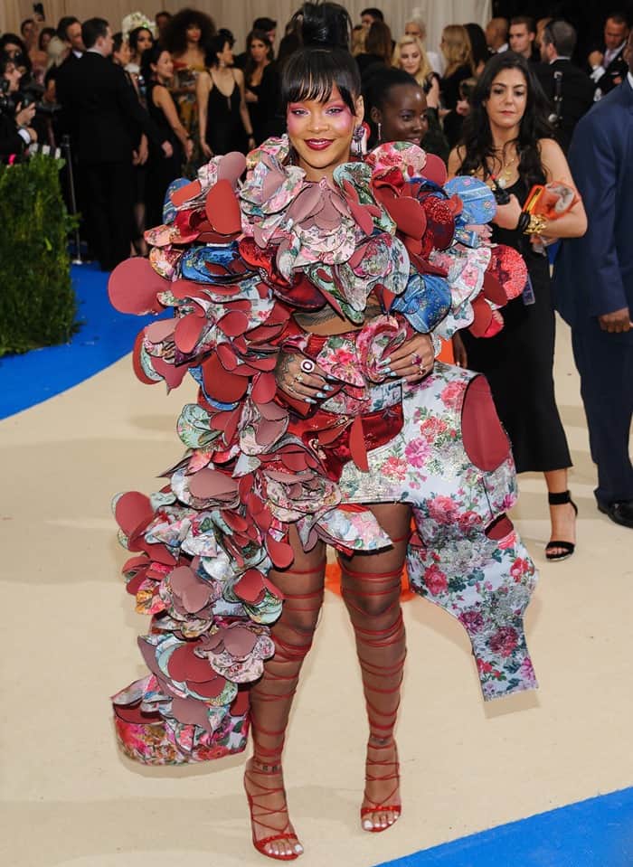 Rihanna wore a bold, architectural pink-and-blue mini-dress from Rei Kawakubo’s Fall 2016 Ready-to-Wear collection, which featured dramatic, oversized 3D flower embellishments enveloping the torso and two sculptural pieces extending down the sides