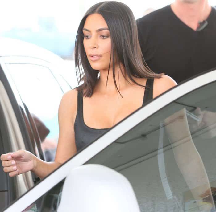 Kim Kardashian wears a sleeveless top while getting into her car