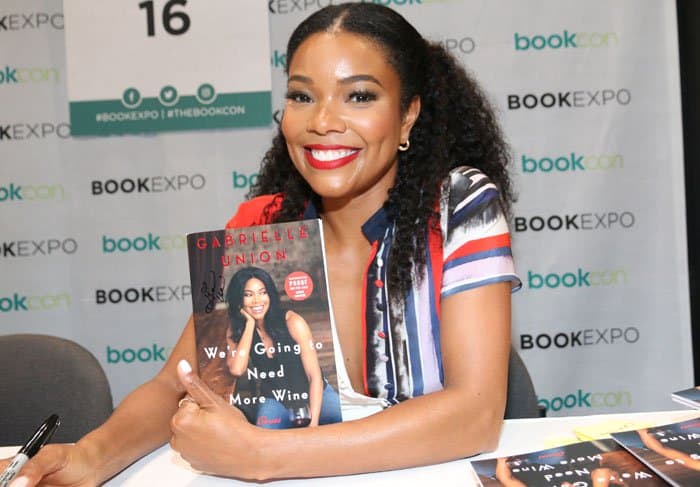 Gabrielle poses with a signed copy of her book titled We’re Going to Need More Wine