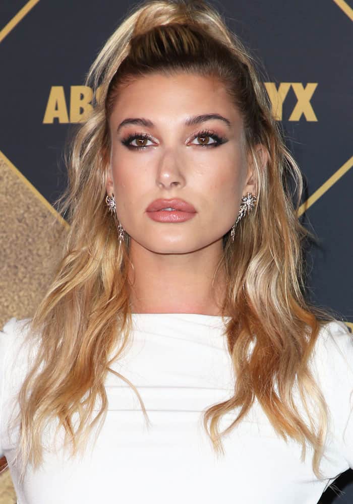 Hailey Baldwin showcases a chic, half-up hairstyle paired with bronzed, dewy makeup and dramatic eye accents at the 2017 Maxim Hot 100 party