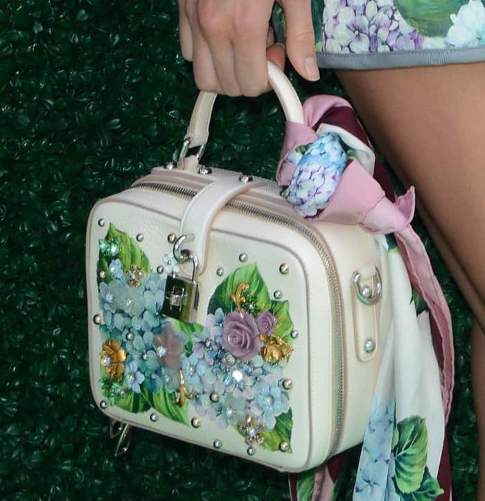 Kendall Jenner added a chic touch to her Dolce & Gabbana box bag by tying a matching silk scarf from the Ortensia collection, enhancing its elegant floral detailing