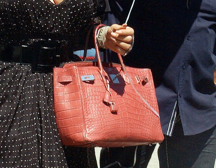 Mariah Carey styled her polka dot dress with a stunning red crocodile Hermes Birkin bag.