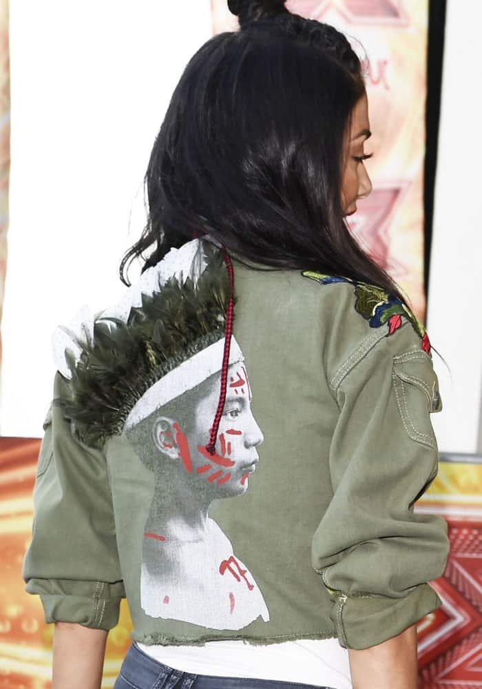 Nicole wears a jacket with a feathered graphic print at the back