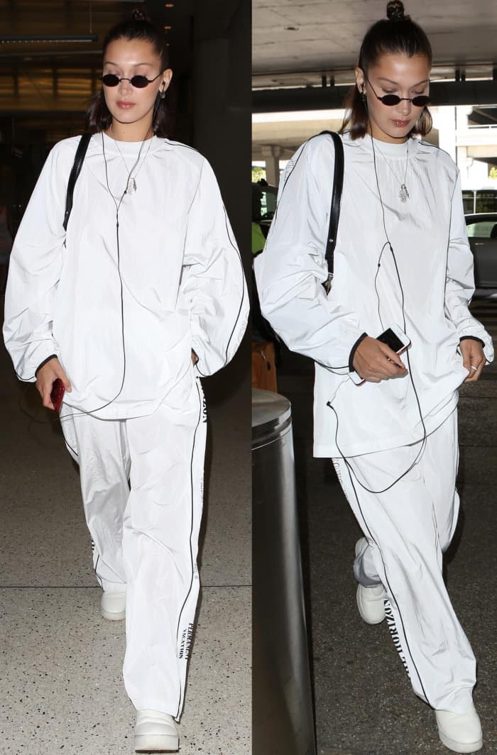 Bella Hadid was spotted at LAX Airport on June 21, 2017, wearing a Hyein Seo tracksuit with Celine pull-on sneakers, Roberi & Fraud sunglasses, and a Versus Versace buckle clutch