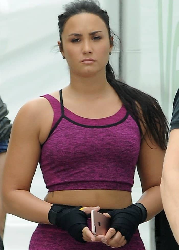 Demi Lovato flaunts her midriff in a purple sports bra