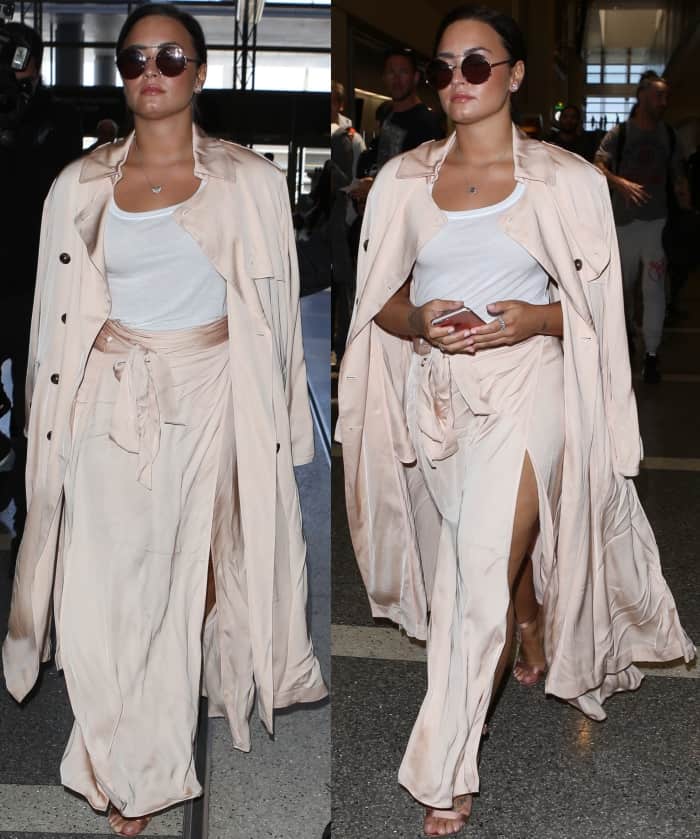 Demi Lovato's soft peach skirt features a wraparound waist tie, a high side slit, and an ankle-grazing hem